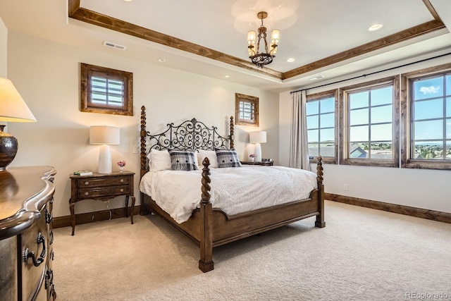 bedroom with a raised ceiling, baseboards, visible vents, and light colored carpet