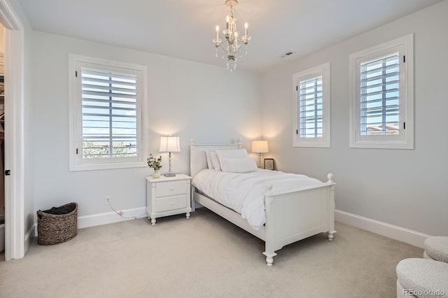 bedroom with light colored carpet, baseboards, a chandelier, and multiple windows