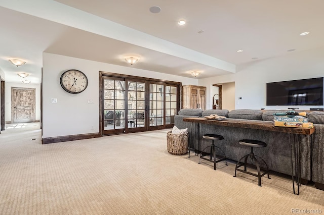 living area with baseboards, light carpet, and french doors