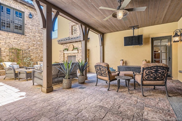 view of patio / terrace featuring an outdoor living space with a fireplace and a ceiling fan