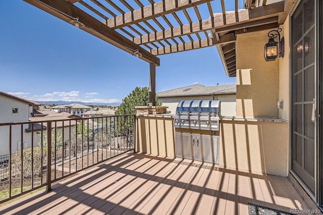 deck with exterior kitchen, a residential view, a pergola, and area for grilling