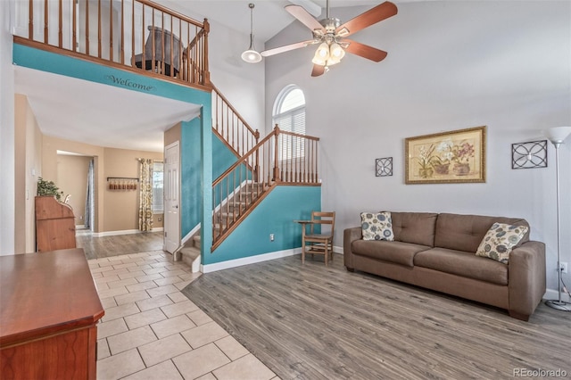 living room with ceiling fan, high vaulted ceiling, and light hardwood / wood-style flooring