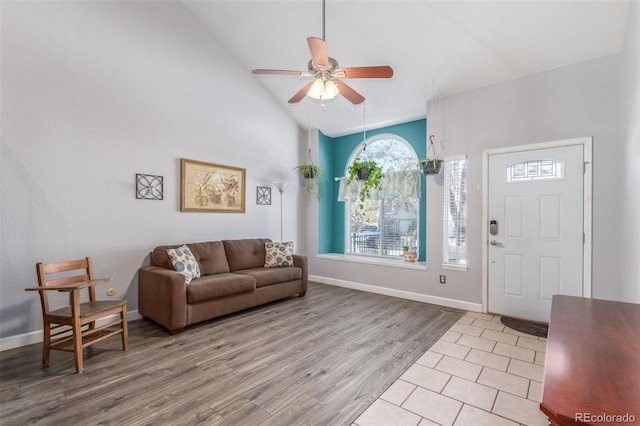 entryway with high vaulted ceiling, ceiling fan, and light wood-type flooring