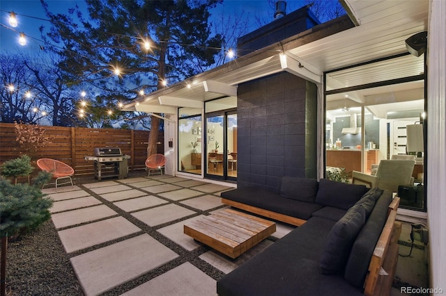 view of patio with an outdoor living space, fence, and a grill