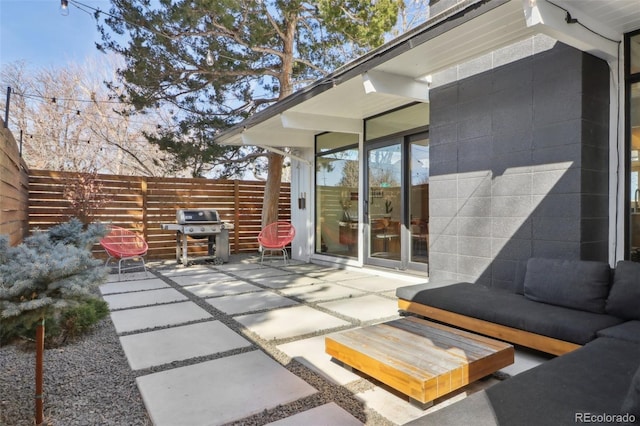 view of patio with an outdoor living space, area for grilling, and fence