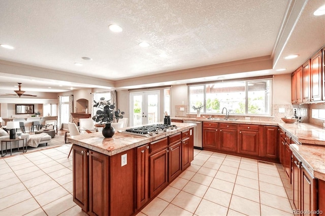 10085 Charissglen Ct, Highlands Ranch, CO 80126 - kitchen featuring stainless steel appliances, light tile patterned floors, a textured ceiling, plenty of natural light, and a center island