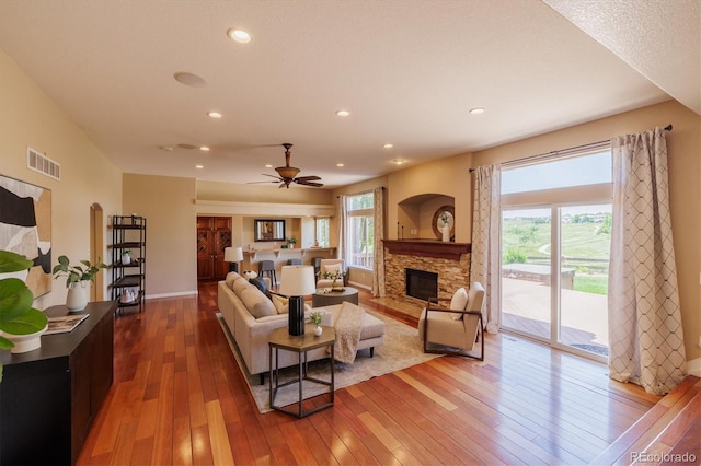 10085 Charissglen Ct, Highlands Ranch, CO 80126 - living area with hardwood / wood-style flooring, a stone fireplace, ceiling fan, and recessed lighting