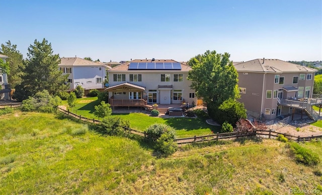 10085 Charissglen Ct, Highlands Ranch, CO 80126 - rear view of house with a wooden deck, a fenced backyard, a residential view, and solar panels