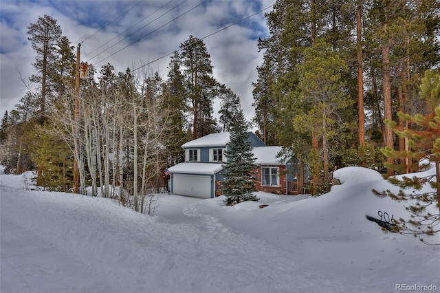 snow covered property with a garage