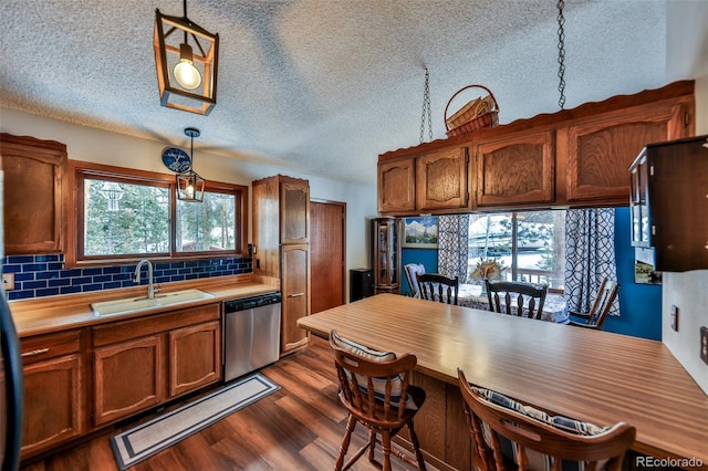 kitchen with pendant lighting, dishwasher, sink, and tasteful backsplash