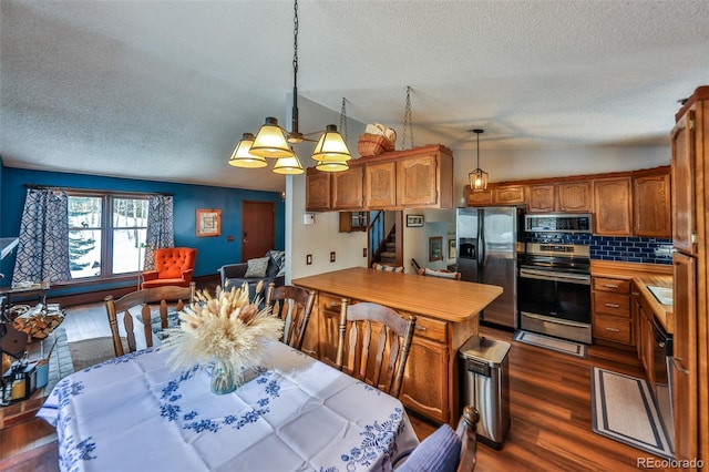 kitchen featuring pendant lighting, backsplash, dark hardwood / wood-style floors, and stainless steel appliances