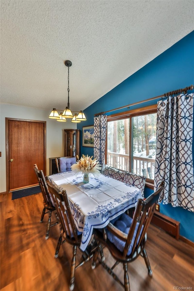 dining space featuring vaulted ceiling, a textured ceiling, and dark wood-type flooring