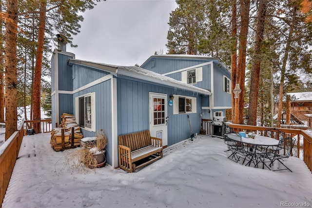 view of snow covered back of property