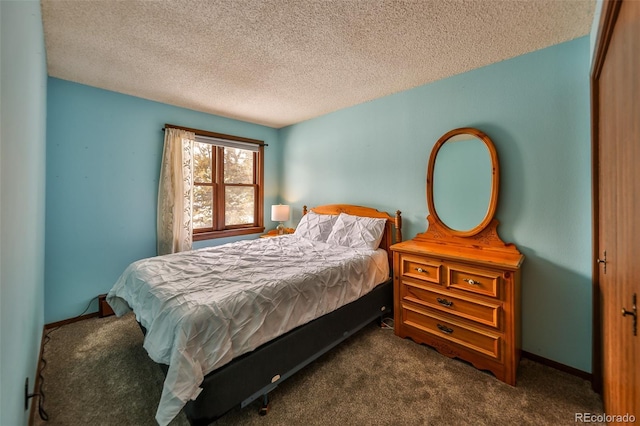 bedroom featuring dark carpet and a textured ceiling