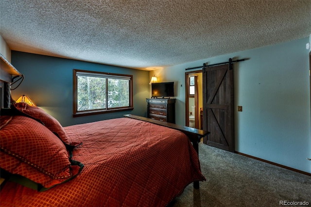 bedroom with a textured ceiling, a barn door, and carpet floors