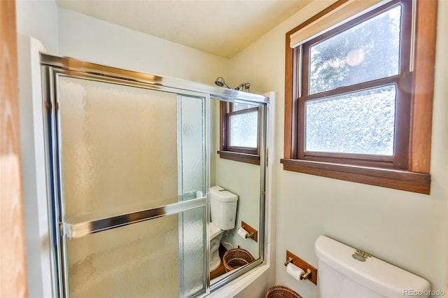 bathroom featuring toilet, a healthy amount of sunlight, and walk in shower