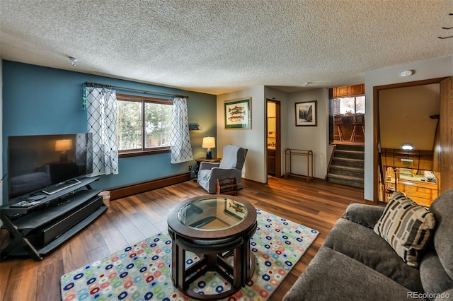 living room with dark hardwood / wood-style floors, a textured ceiling, and a baseboard heating unit