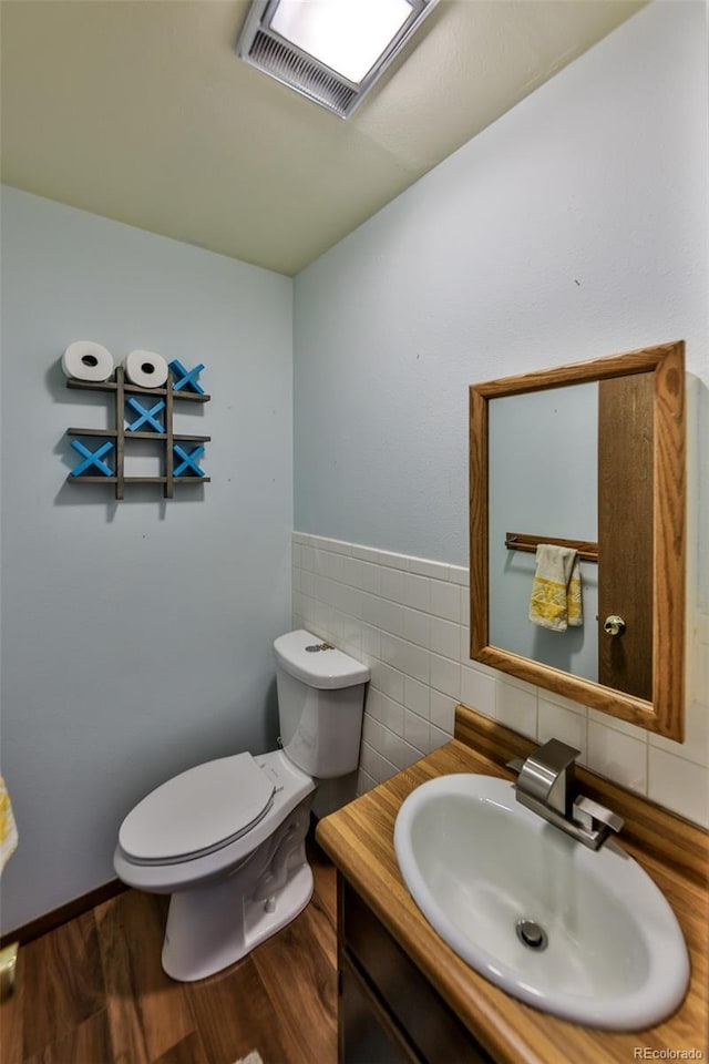 bathroom featuring hardwood / wood-style floors, vanity, toilet, and tile walls