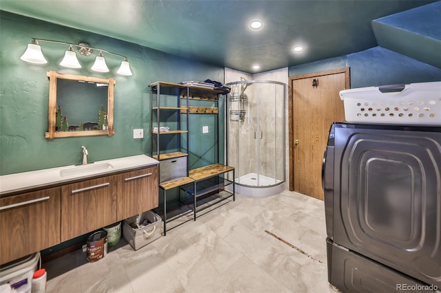 bathroom featuring washer / clothes dryer, vanity, a shower with shower door, and lofted ceiling