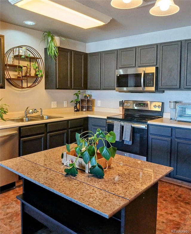 kitchen with dark tile patterned flooring, sink, and appliances with stainless steel finishes