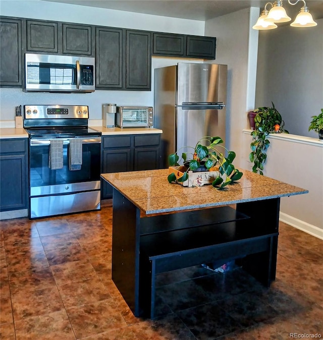 kitchen with a chandelier, light stone countertops, pendant lighting, and stainless steel appliances