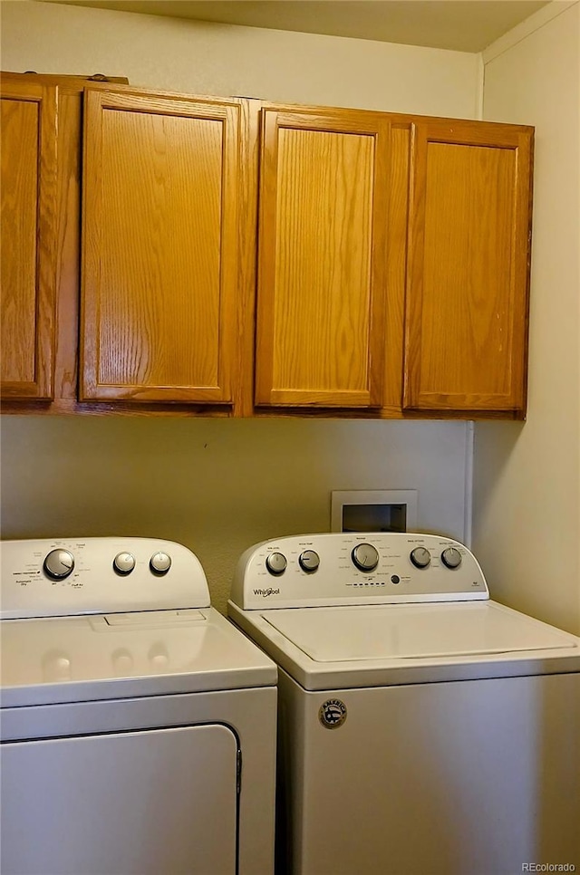 washroom featuring washing machine and clothes dryer and cabinets