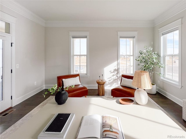 sitting room with a healthy amount of sunlight, dark hardwood / wood-style floors, and ornamental molding