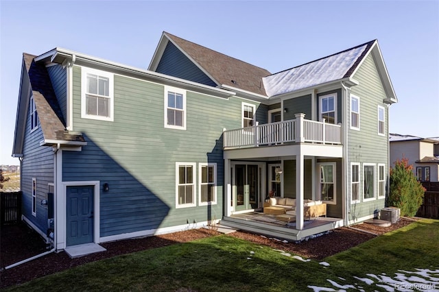 rear view of house with a yard, central AC, and a balcony