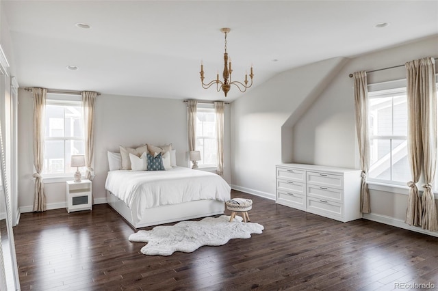 bedroom featuring dark hardwood / wood-style floors, lofted ceiling, and an inviting chandelier