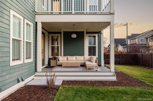 patio terrace at dusk with a lawn, a balcony, and an outdoor hangout area