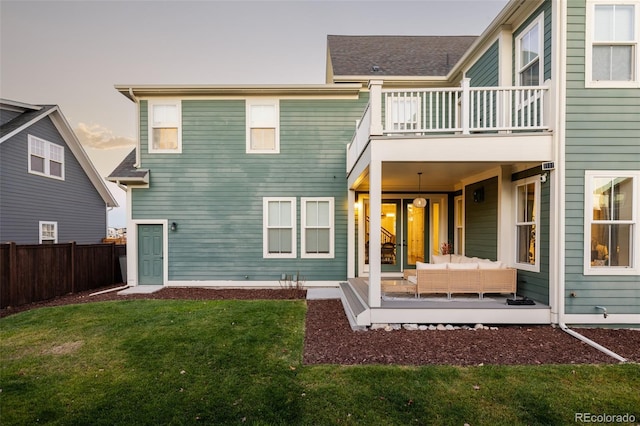 back of house featuring an outdoor hangout area, a balcony, and a lawn