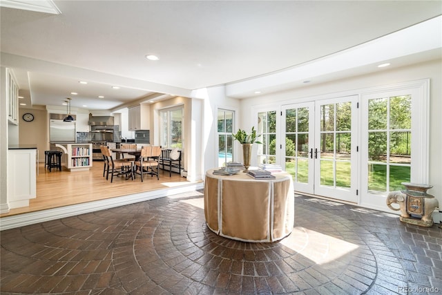 living area with recessed lighting, plenty of natural light, and french doors