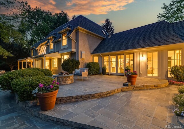1512 Cottonwood Ln, Greenwood Village, CO 80121 - rear view of property featuring an outdoor fire pit, french doors, a patio, stucco siding, and mansard roof