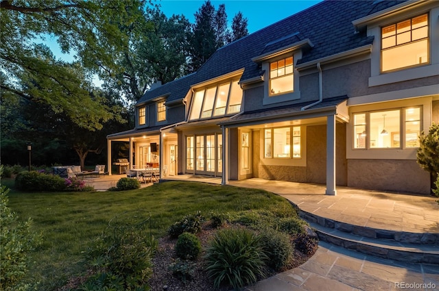 1512 Cottonwood Ln, Greenwood Village, CO 80121 - rear view of house with a patio, stucco siding, a lawn, mansard roof, and a shingled roof