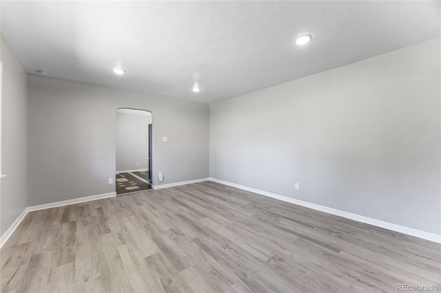 1560 Pueblo Ct, Thornton, CO 80229 - unfurnished room featuring arched walkways, wood finished floors, baseboards, and recessed lighting