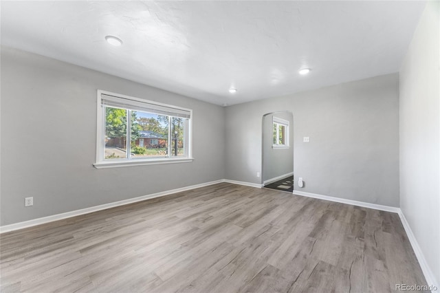 1560 Pueblo Ct, Thornton, CO 80229 - empty room with arched walkways, wood finished floors, and baseboards