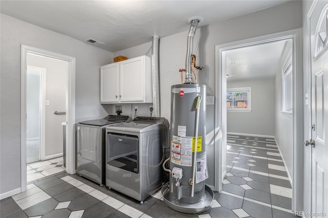 1560 Pueblo Ct, Thornton, CO 80229 - laundry room with cabinet space, gas water heater, washing machine and clothes dryer, and tile patterned floors