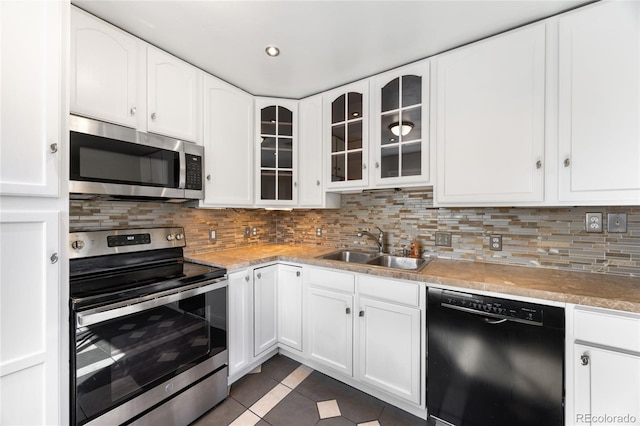 1560 Pueblo Ct, Thornton, CO 80229 - kitchen featuring appliances with stainless steel finishes, a sink, dark tile patterned flooring, white cabinetry, and glass insert cabinets