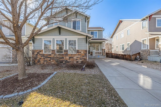 view of front facade featuring stone siding and fence