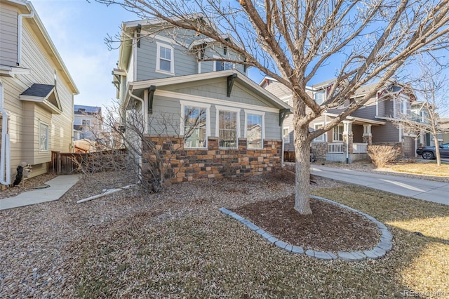 view of front facade with stone siding and fence