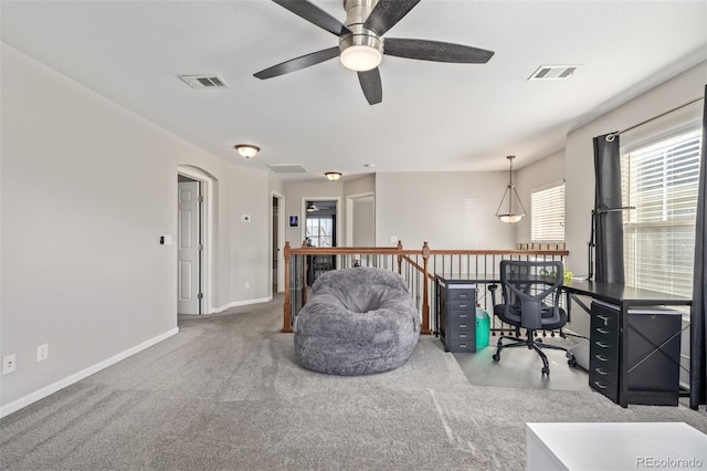 carpeted office with baseboards, visible vents, and arched walkways