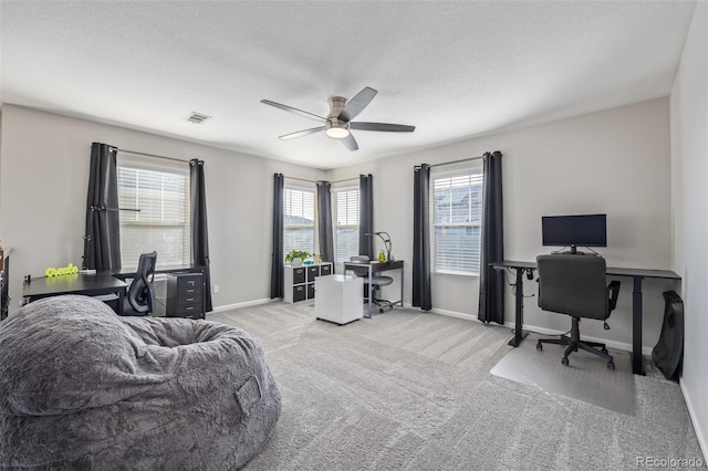 carpeted home office with ceiling fan, a textured ceiling, visible vents, and baseboards