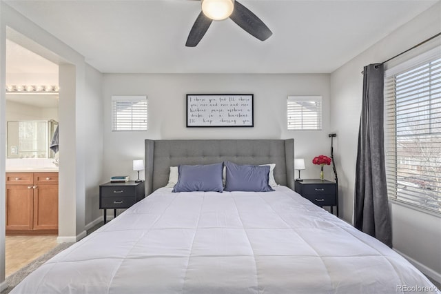 bedroom with ceiling fan, multiple windows, baseboards, and connected bathroom