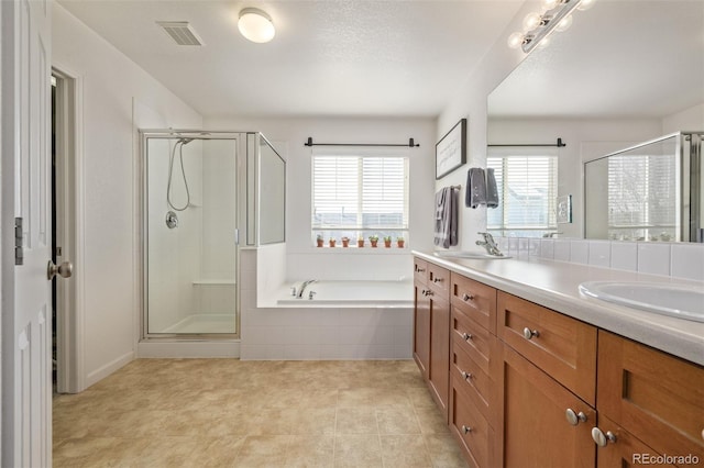 bathroom featuring a healthy amount of sunlight, a stall shower, and visible vents