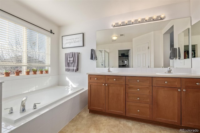 bathroom with a garden tub, a sink, and double vanity