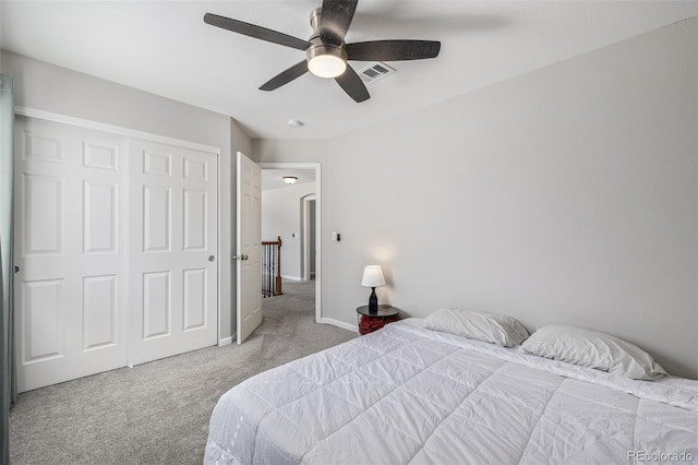 carpeted bedroom featuring a ceiling fan, a closet, visible vents, and baseboards