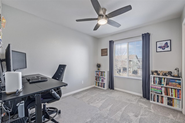 carpeted office space with baseboards and a ceiling fan