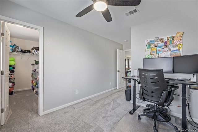 carpeted office with baseboards, visible vents, and ceiling fan