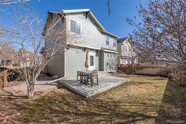 rear view of house featuring a patio area, a lawn, and fence