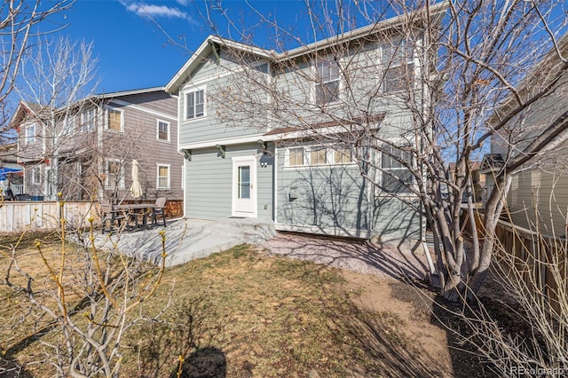 rear view of house featuring a patio and fence